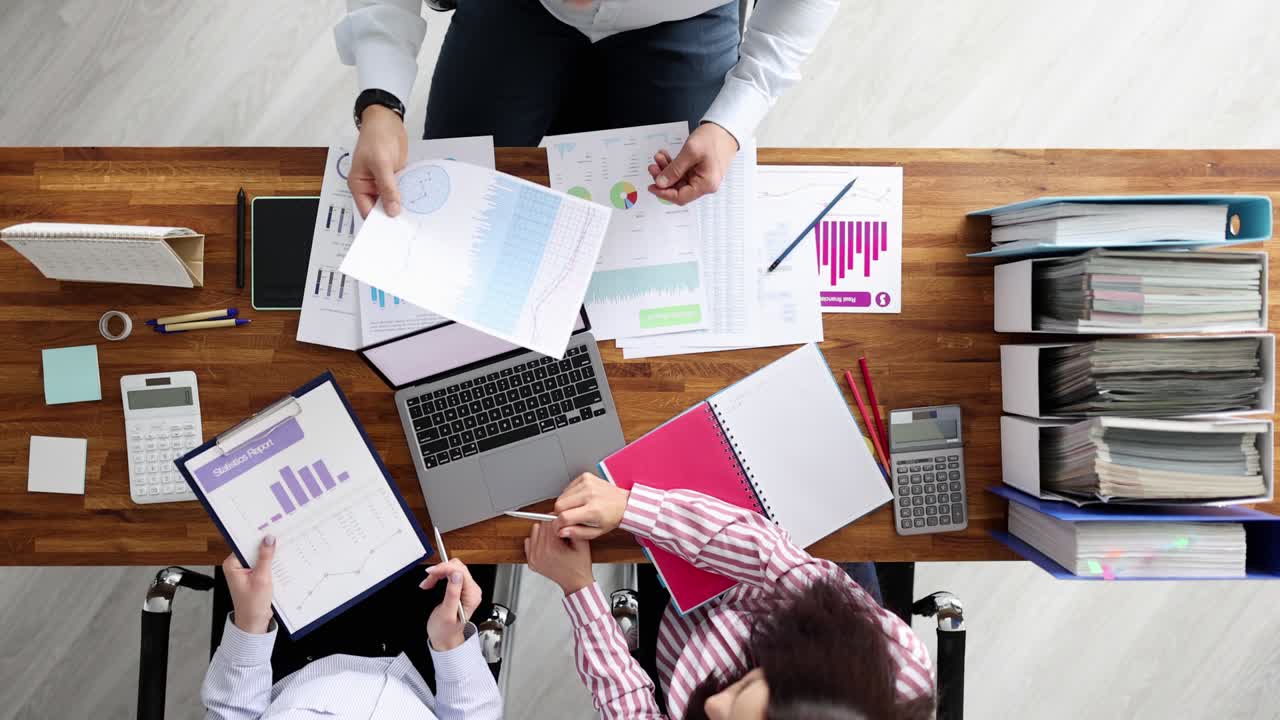 equipo de empresarios discutiendo estadísticas financieras en gráficos