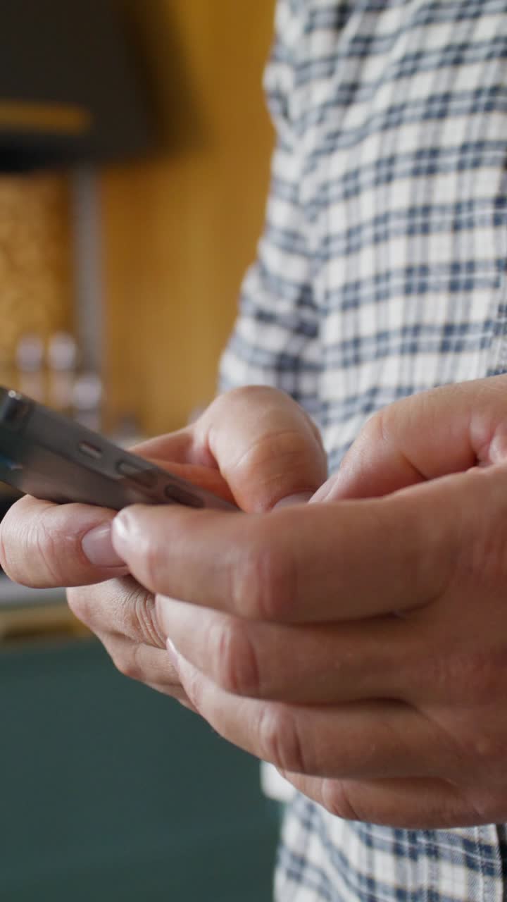 hombre usando un teléfono inteligente en la cocina