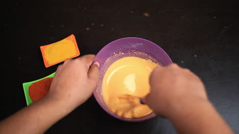 chef mix the mixture of corn flour ,egg ,red chilly powder , salt and water by the whisker