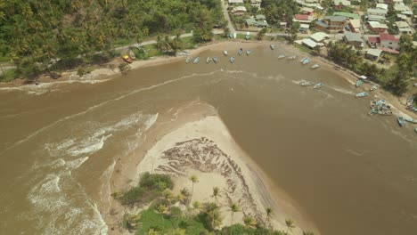 Descending-aerial-view-of-boats-anchored-off-the-fishing-village-of-Mayaro,-Trinidad