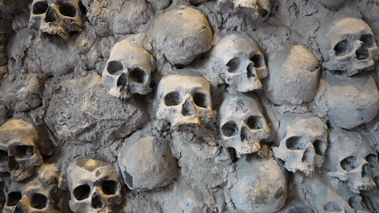 Skulls embedded in a stone wall, Liguria, Italy, showcasing history