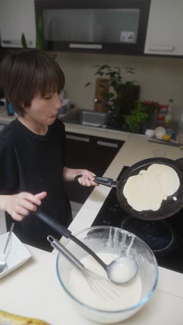 young boy making pancakes in the kitchen