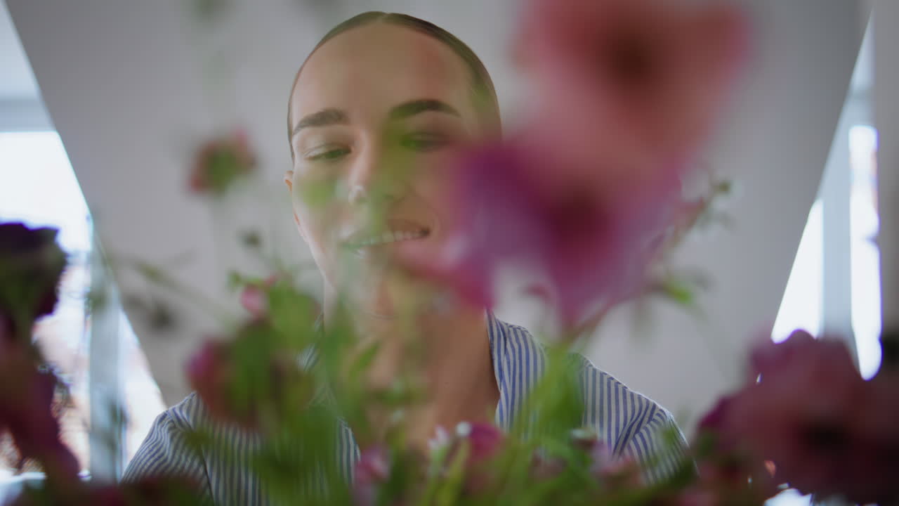 Young lady putting bouquet vase at apartment closeup. Woman decorating kitchen