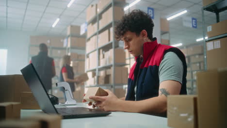 trabajador de almacén usando una computadora portátil y un escáner
