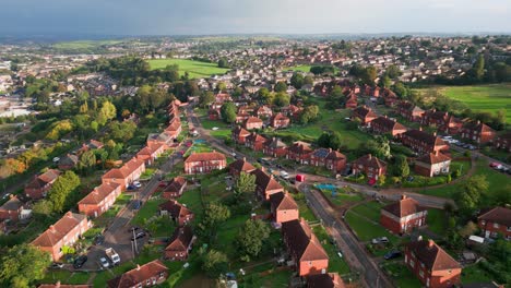 Yorkshire's-council-run-housing:-Aerial-drone-view-of-red-brick-buildings-in-the-UK,-illuminated-by-the-morning-sun,-featuring-bustling-streets-and-homes