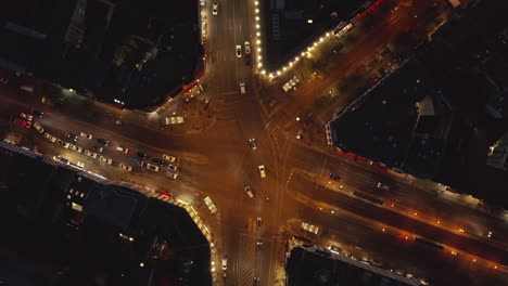 Große-Stadtkreuzung-Mit-Autoverkehr-Bei-Nacht-In-Berlin,-Deutschland-Am-Rosenthaler-Platz-Straßen-Im-Bezirk-Mitte-Mit-Stadtlichtern,-Luftvogelperspektive-Von-Oben-Nach-Unten