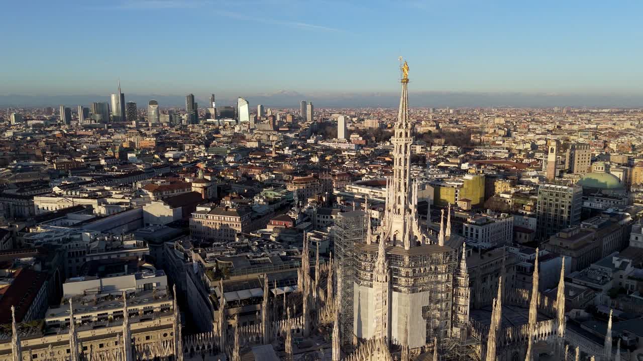 drone close up of Milano duomo cathedral with warm sunset light and view of the cityscape with skyline at distance , smart city European capital