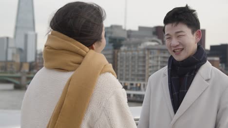 Young-Asian-Couple-With-Romantic-Man-Proposing-To-Woman-Against-City-Skyline-2