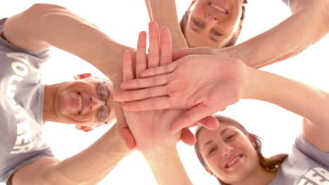 group of volunteers putting hands together