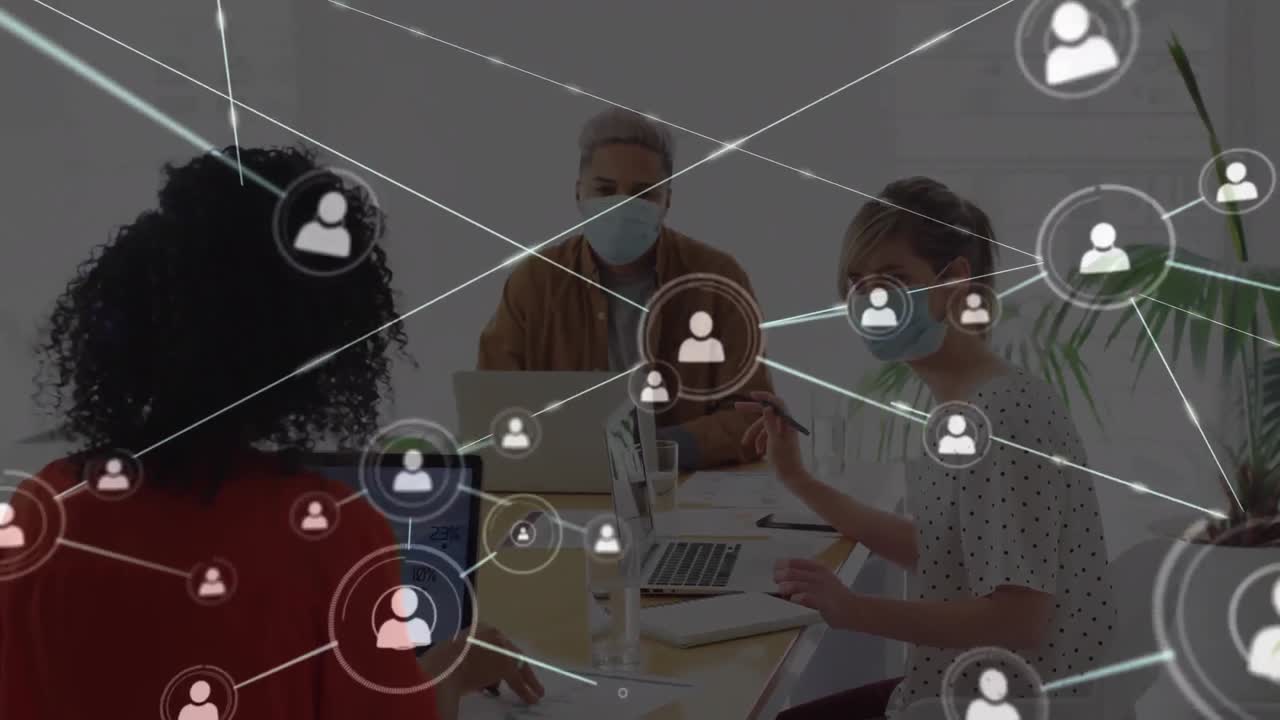 animación de iconos de personas de la red sobre diversos colegas creativos con máscaras faciales trabajando en computadoras portátiles
