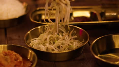 using chopsticks to skillfully pick up bean sprouts