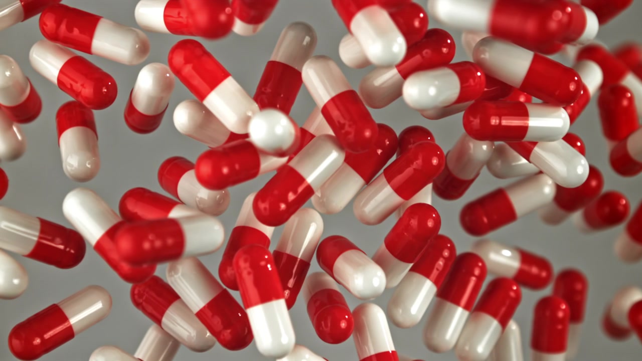 Capsule mediche rosse e bianche che cadono al rallentatore