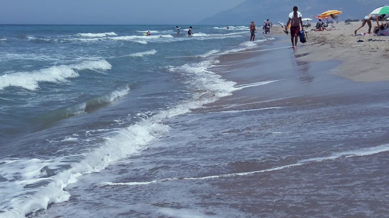 People enjoying the waves on a sunny beach day