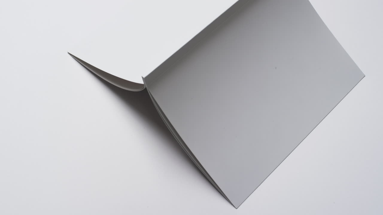 Video of book with white blank cover pages and copy space on white background