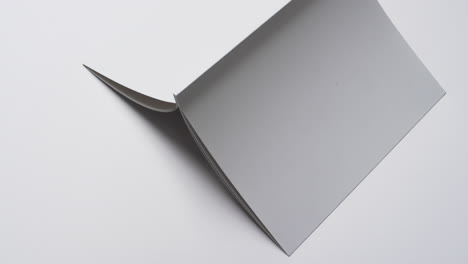 video of book with white blank cover pages and copy space on white background