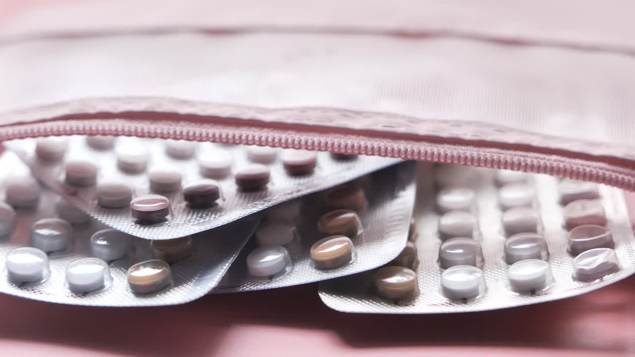 분홍색 가방에 담긴 몇 개의 블리스터 패키지의 약물의 클로즈업