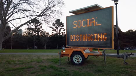 señal de advertencia de distanciamiento social en el montaje del remolque al aire libre en el parque de sydney, lento