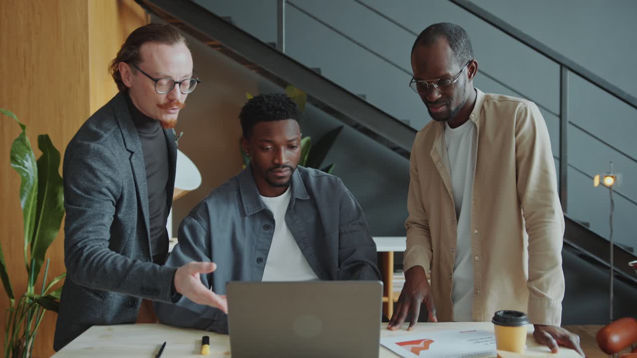Business Team Discussing Project on Laptop in Office