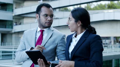 compañeros de trabajo sonrientes con dispositivos digitales