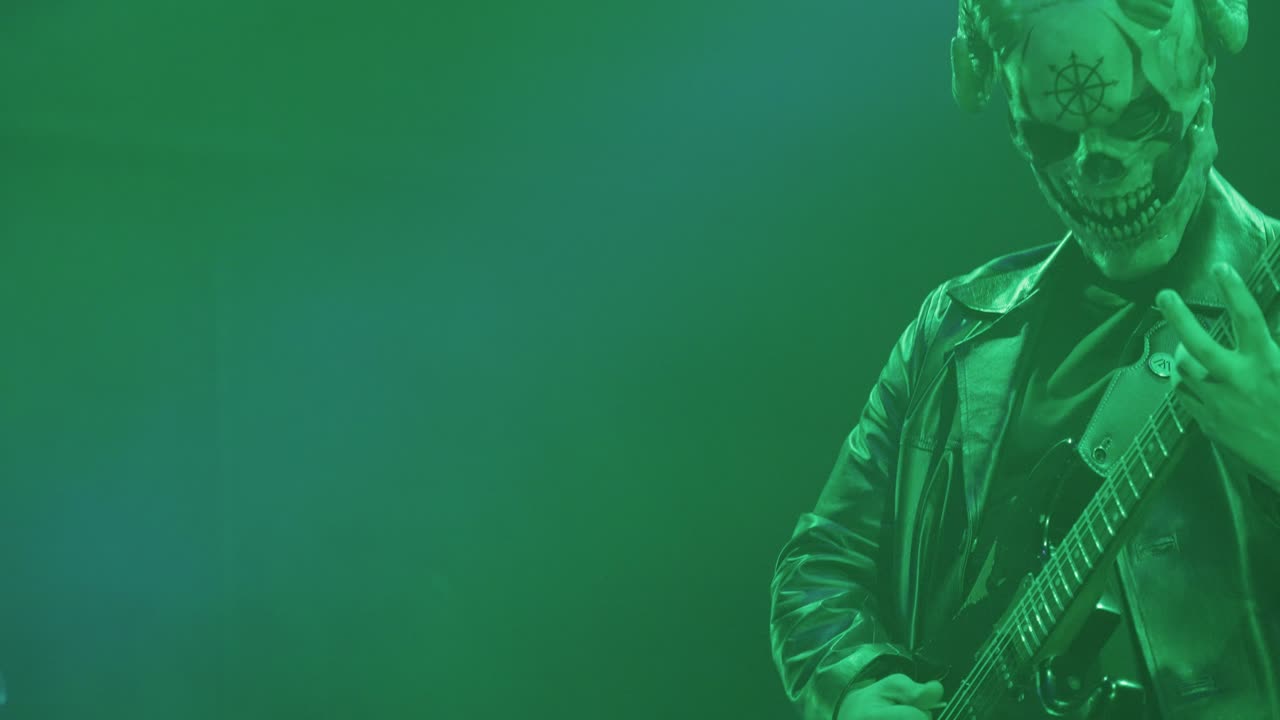 Musician in Skull Mask Playing Electric Guitar on Stage