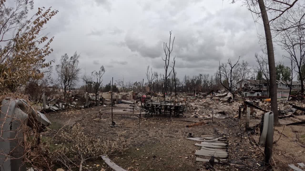 A lone dining table remains standing. Charred debris surrounds it, an eerie contrast between destruction and survival. Perfect for news, documentaries, and storytelling.
