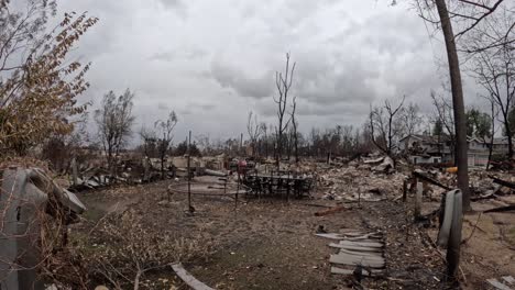 a lone dining table remains standing. charred debris surrounds it, an eerie contrast between destruction and survival. perfect for news, documentaries, and storytelling.