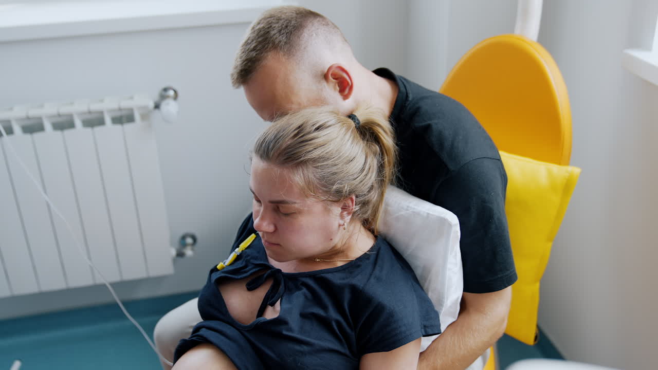 Man supporting his wife at childbirth holding her from behind. Woman having contractions before delivering a baby.