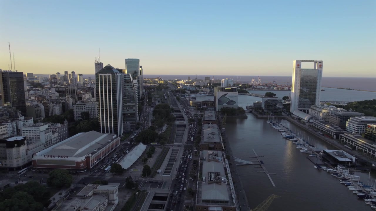 Vista aerea 4K con drone di Puerto Madero a Buenos Aires, Argentina, al tramonto. Skyline moderno riflesso sul lungomare durante l'ora d'oro nel quartiere più contemporaneo della città.