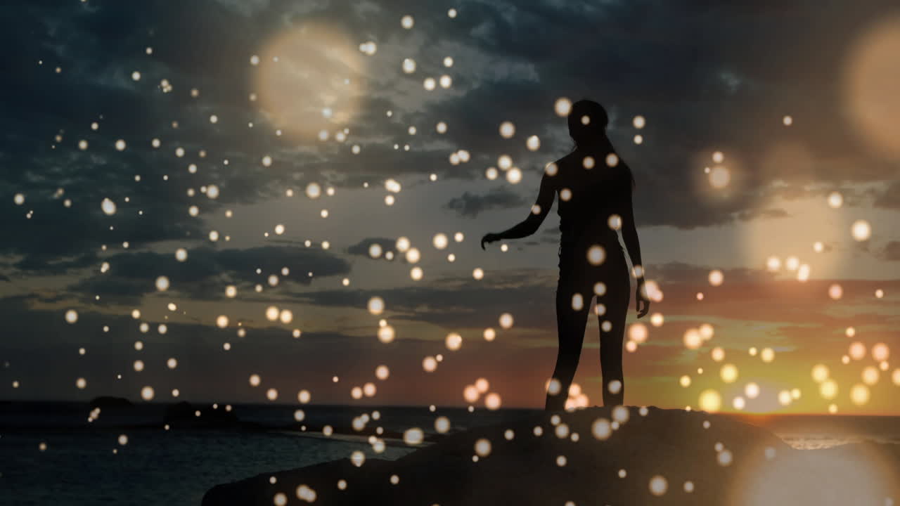 해가 지는 동안 반이는 보케 조명 애니메이션 위에서 춤을 추는 사람의 실루