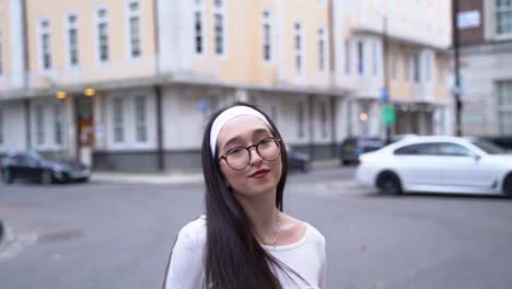 Young-woman-turns,-hair-flips,-smiles,-Soho,-London,-close-up-slow-motion