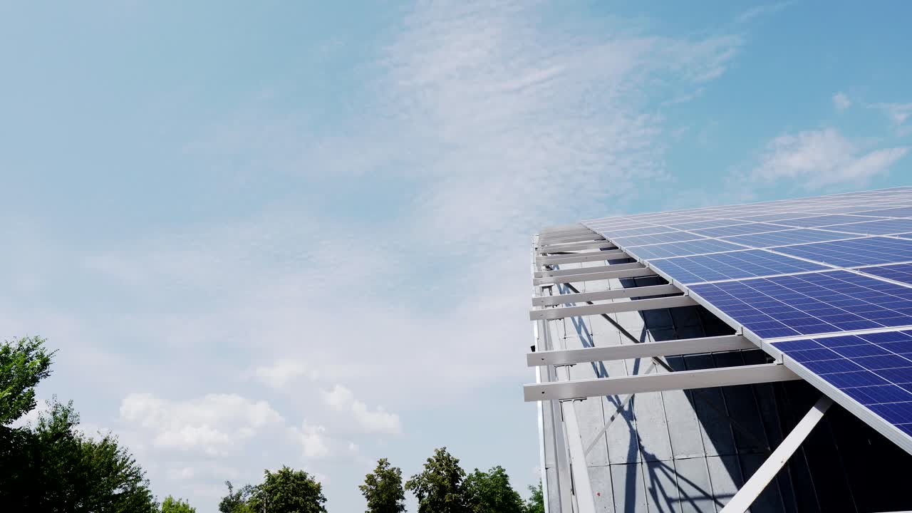 the structure of solar panels on the roof of the house against a blue sky with clouds