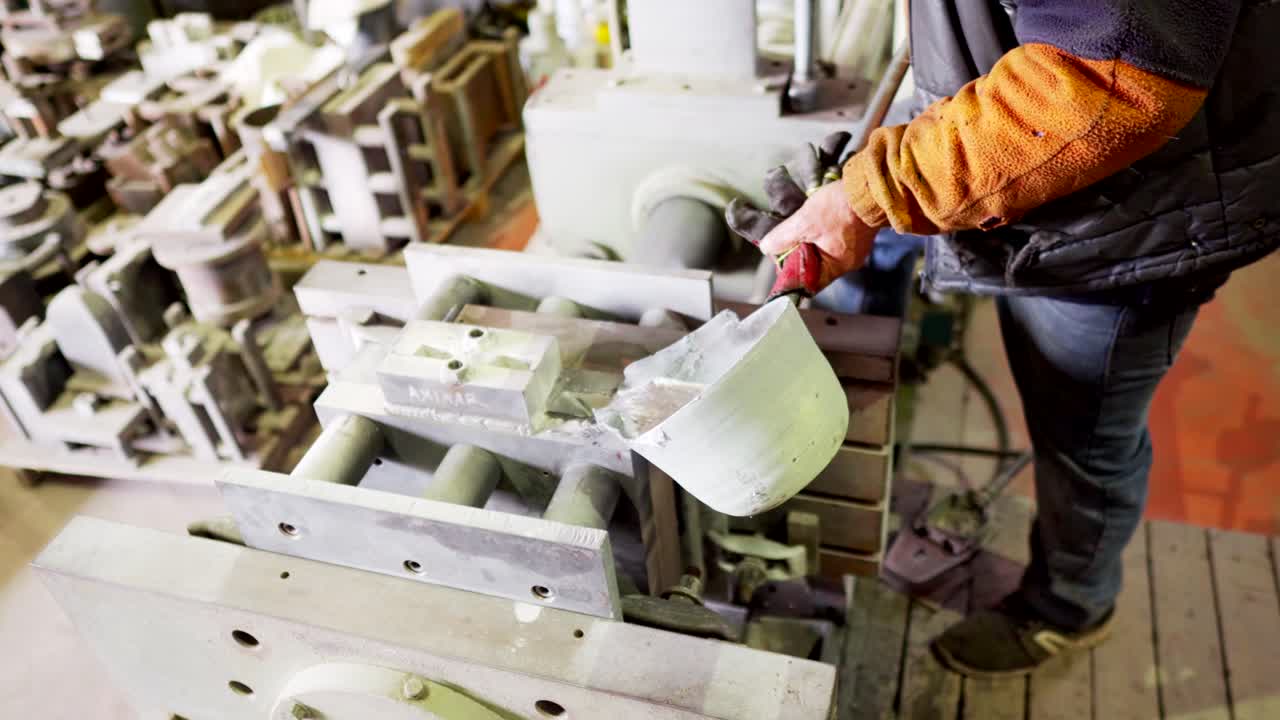 molde permanente de aluminio fundido vertido a mano por un trabajador masculino