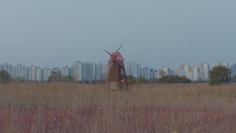Windmühlen-Auf-Dem-Feld,-Ländliches-Dorf-Mit-Stadtgebäuden-Im-Hintergrund,-Weitwinkel-Panoramablick