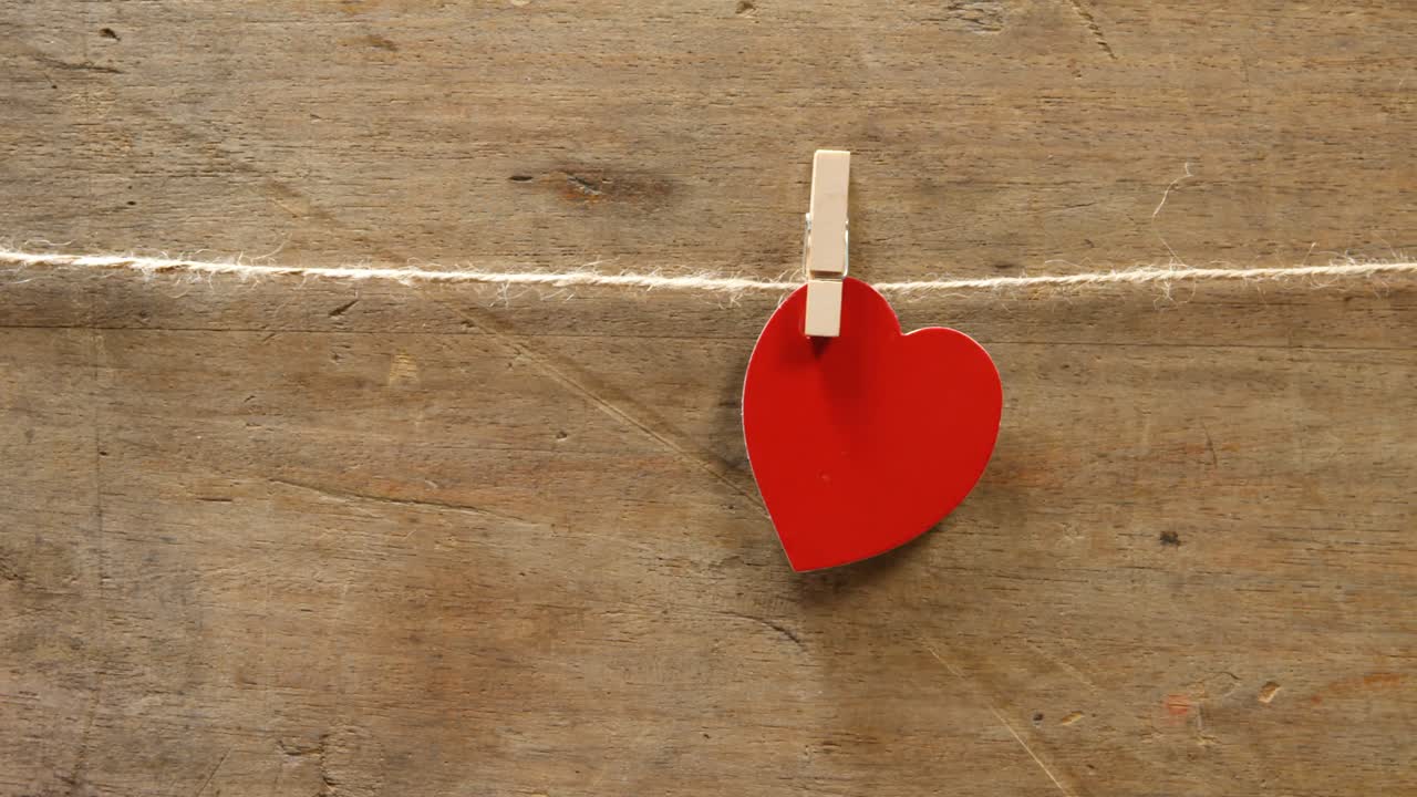 rojo en forma de corazón fijado en una cuerda 4k