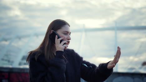 mujer hablando en el teléfono inteligente en la calle. chica atractiva usando el teléfono celular para llamar