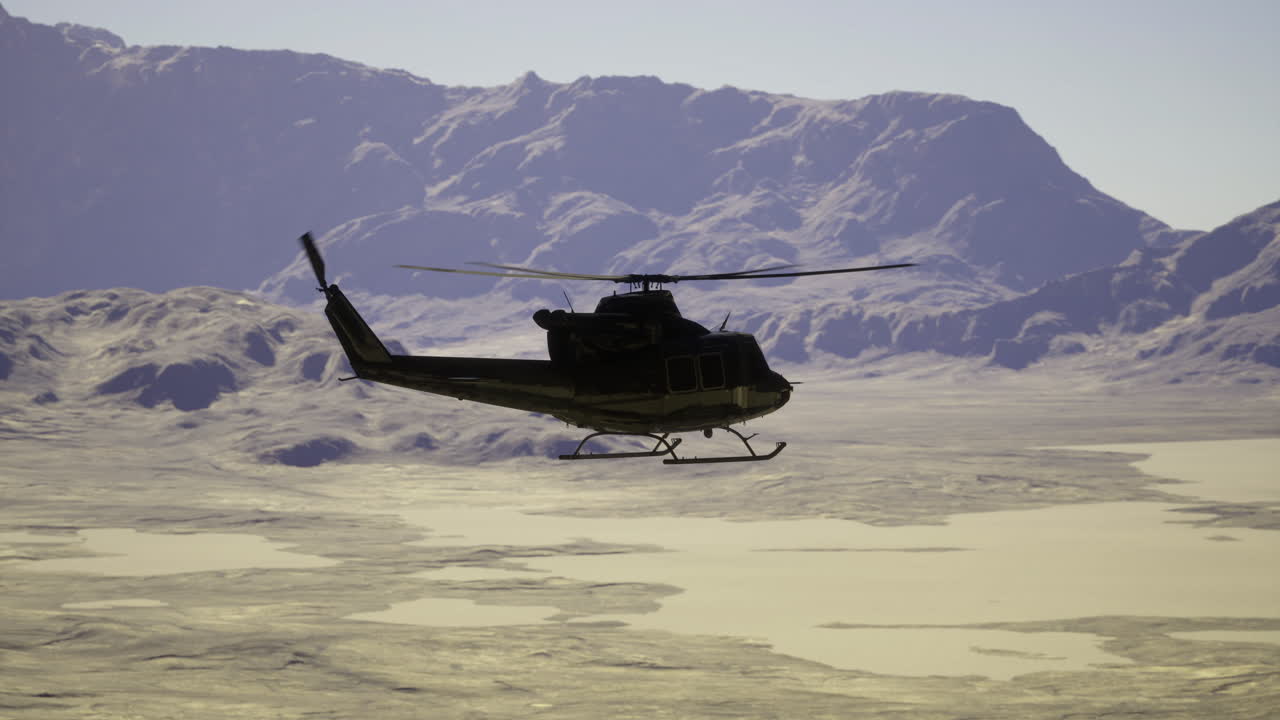 Helicopter flying over arid landscape with mountains in the background