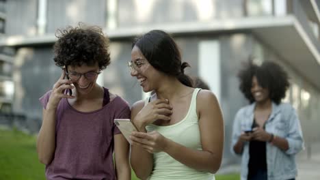 mujeres felices mirando su teléfono inteligente y riendo
