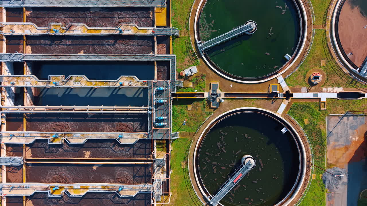 Symmetrical top view of water treatment plant sections. Aerial flat lay of industrial tanks showing different stages of water purification process