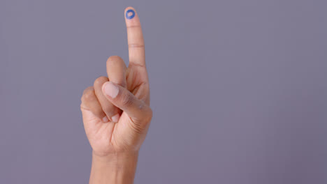 hand of biracial man with blue circle on finger on grey background, copy space, slow motion