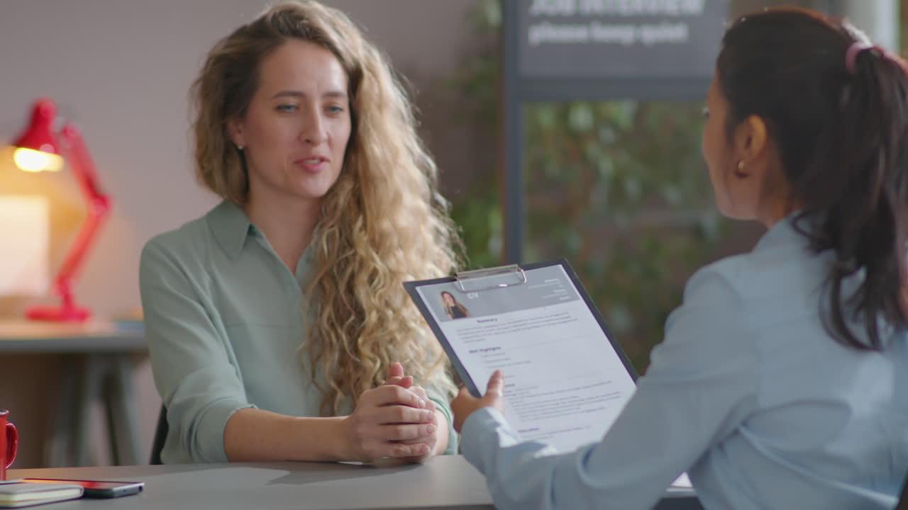 Woman Giving CV and Talking to Recruiter on Job Interview