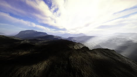 serene mountain landscape under a cloudy sky with distant hills at sunset