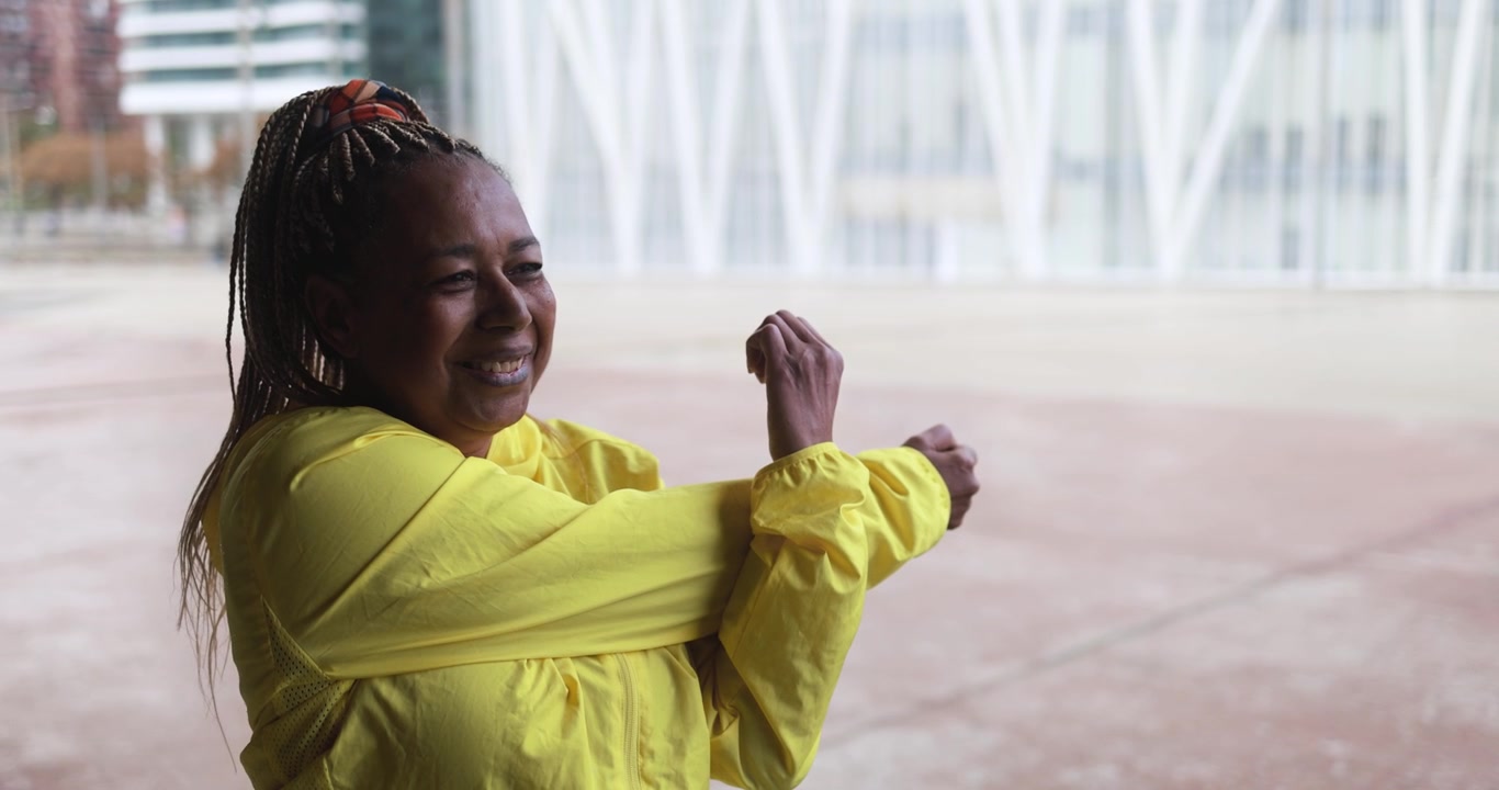 Mature Woman Stretching Arms Outdoors in Urban Setting