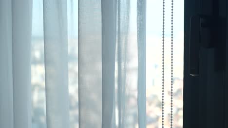 window with sheer curtains and city view