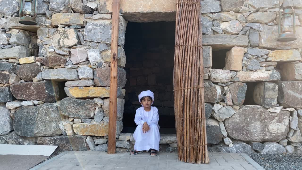 Taştan yapılmış geleneksel bir Arap evinde Arap çocuk.