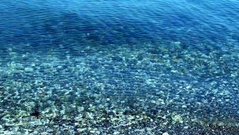 las olas del mar y la maravillosa isla detrás de las piedras costeras