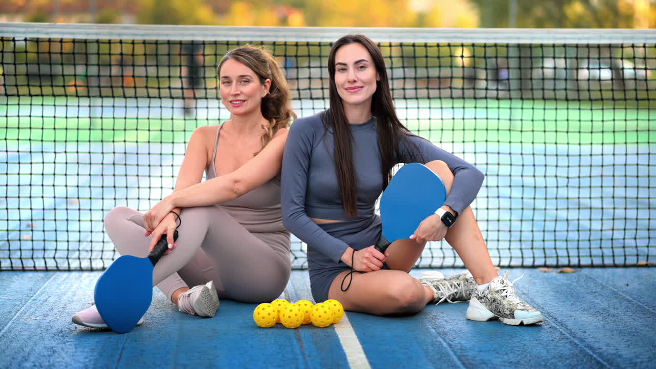 Two women playing pickleball on a court