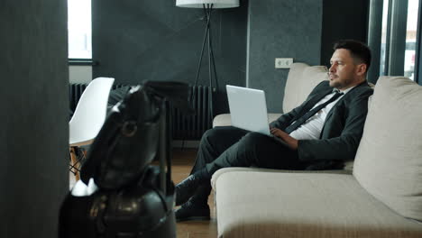 businessman working on laptop in airport lounge