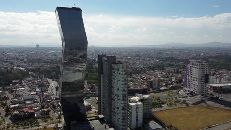 Toma-Aérea-Acercándose-Al-Rascacielos-De-Arquitectura-Moderna