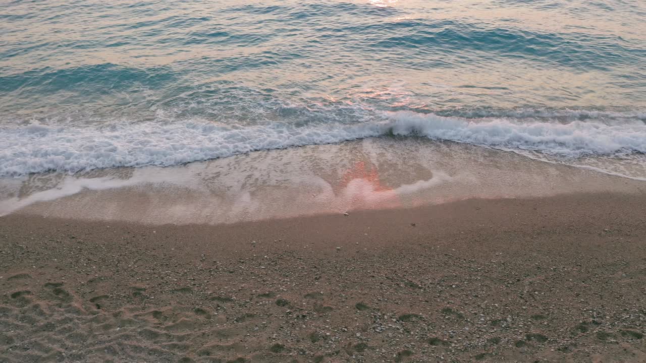 그리스의 이오니아 섬 레프카다 (lefkada) 의 아름다운 미로스 해변 (milos beach) 의 낮은 고도에서 볼 수 있는 풍경: 해가 지고 황금빛의 빛과 순수한 파도가 바가에서 푸른 푸른 바다를 깨뜨린다.