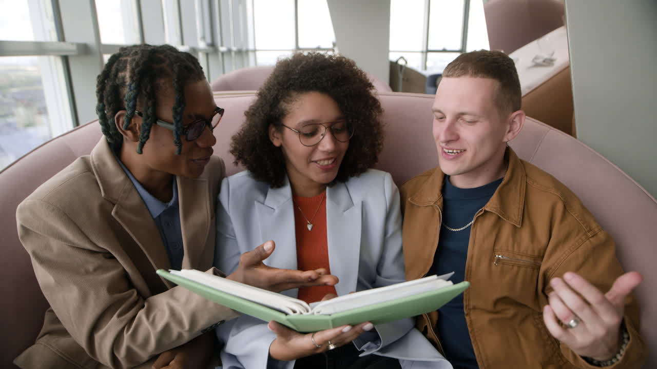 Three people looking through a photo album